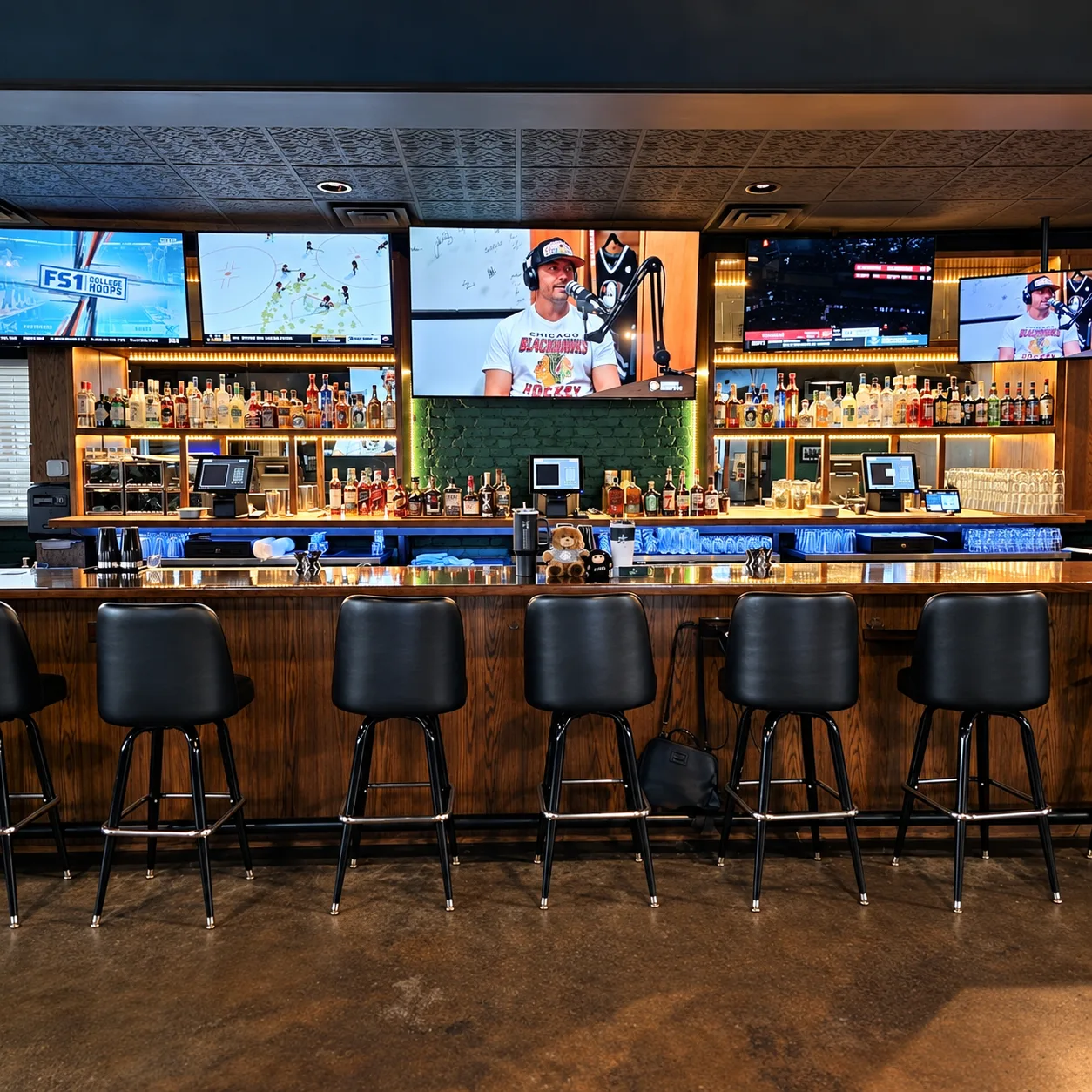 Bar stools and the back bar with TVs inside Morton's Tavern in Fort Worth